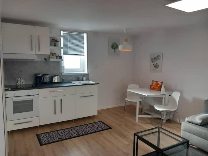 a kitchen and a living room with a table at Zárda utcai Apartman in Kaposvár