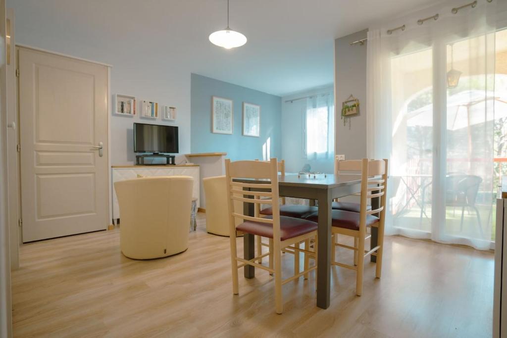 グレウー・レ・バンにあるStudio Coté Jardinのテーブルと椅子のあるキッチンとダイニングルーム