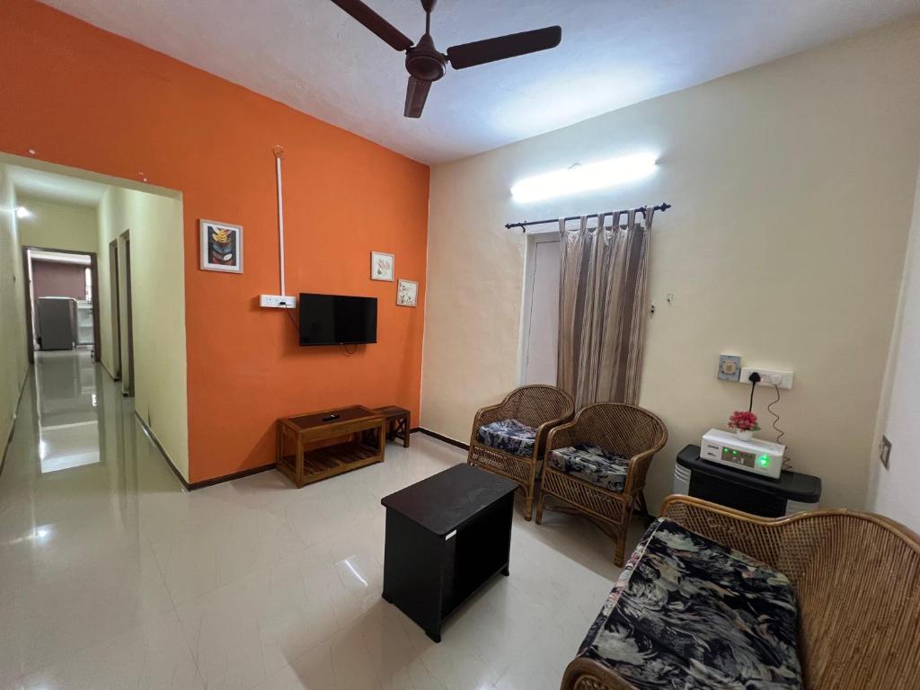 a living room with a couch and a tv at SHI's 2BHK home in Coimbatore near Sai Baba Colony, Ganga C Hospital, Women's care in Coimbatore