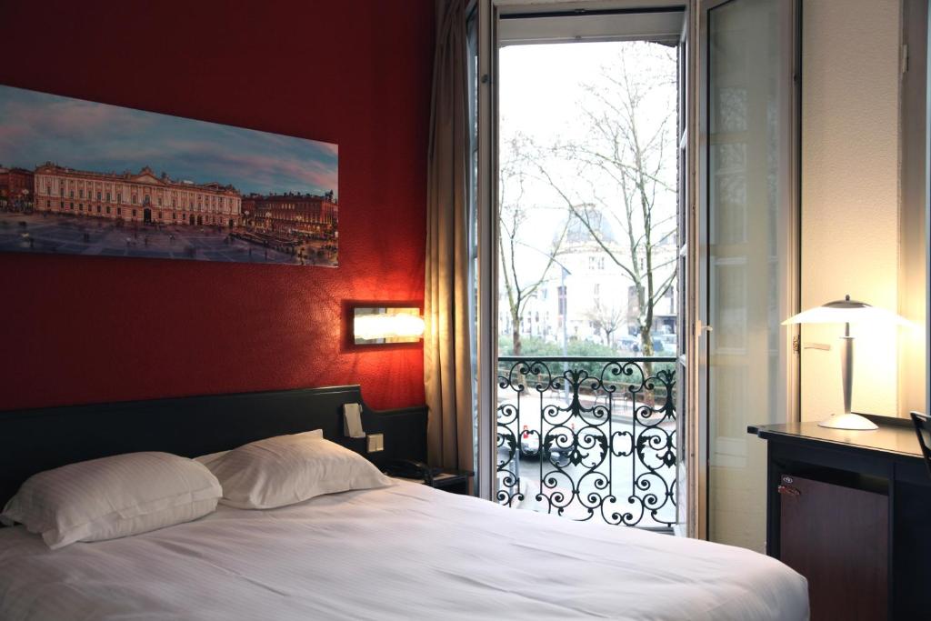 ein Schlafzimmer mit einem Bett und einem großen Fenster in der Unterkunft Occitania Centre Toulouse Matabiau in Toulouse