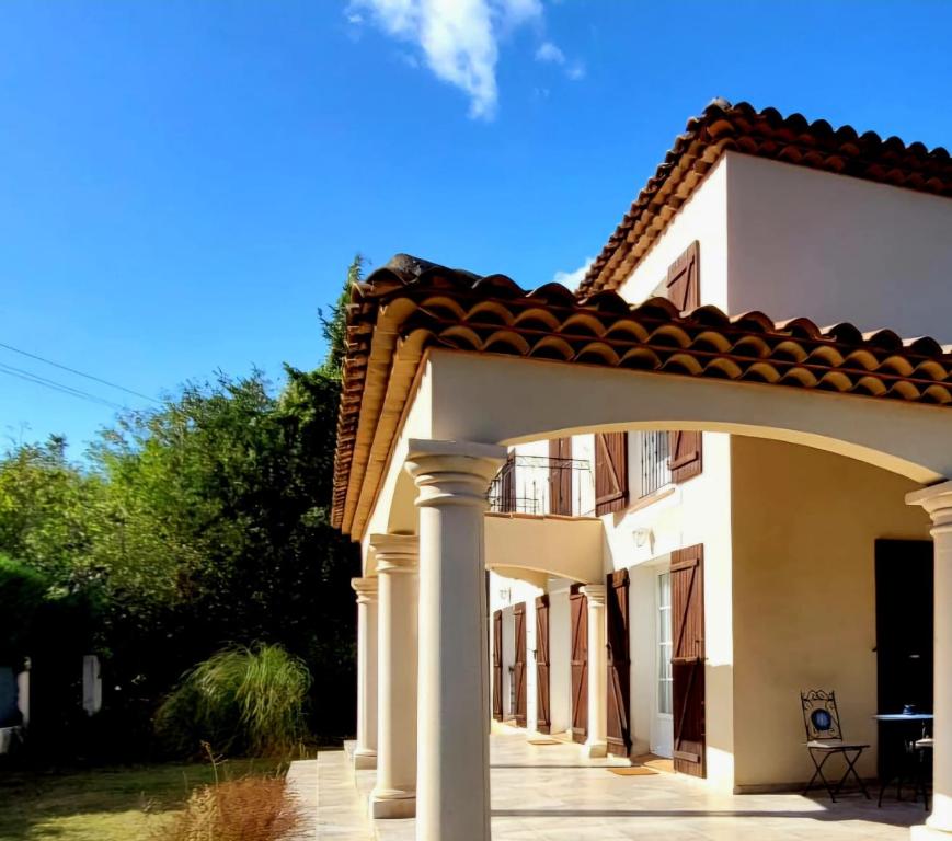 une grande maison blanche avec une arche dans l'établissement Bastide Familiale, à Aix-en-Provence
