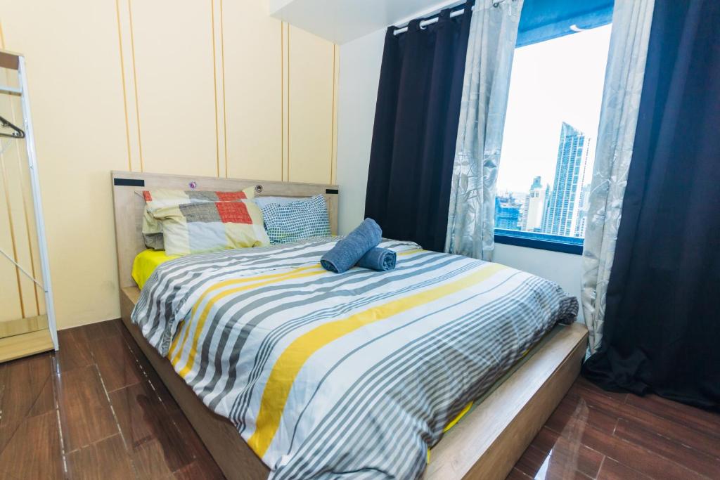 a small bedroom with a bed with a window at The Vibrant Condo Cool Stays 4254 Memorable Swim Gym Park Laugh in Manila