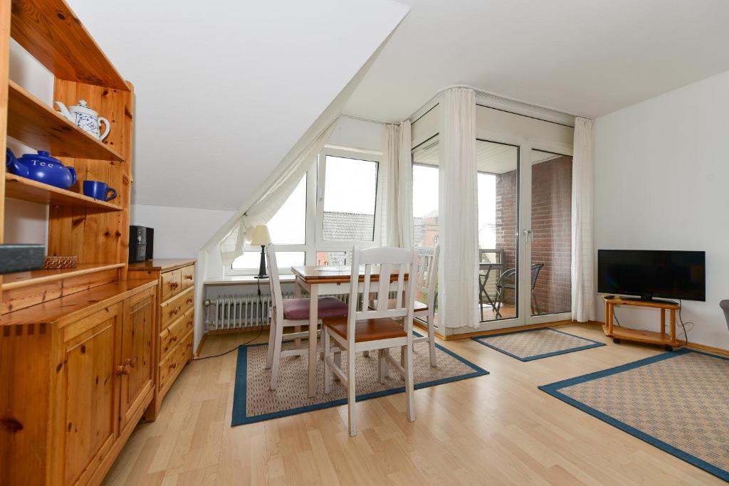 a living room with a table and chairs and a television at Sandwall Whg 2 Langeness in Wyk auf Föhr
