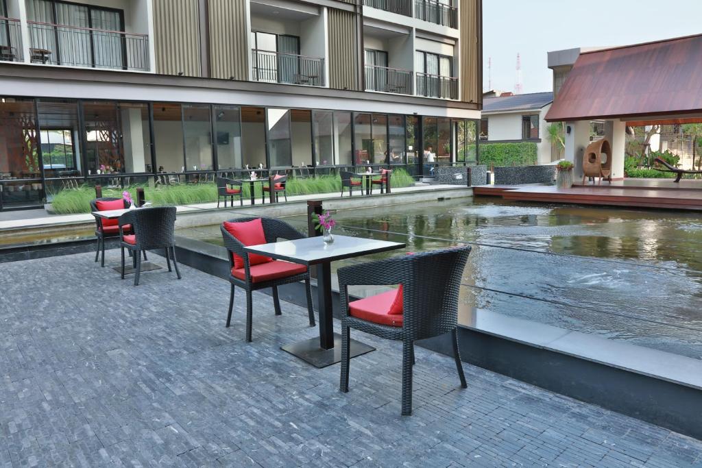 a restaurant with tables and chairs next to a fountain at Amanta Hotel Nongkhai in Nong Khai