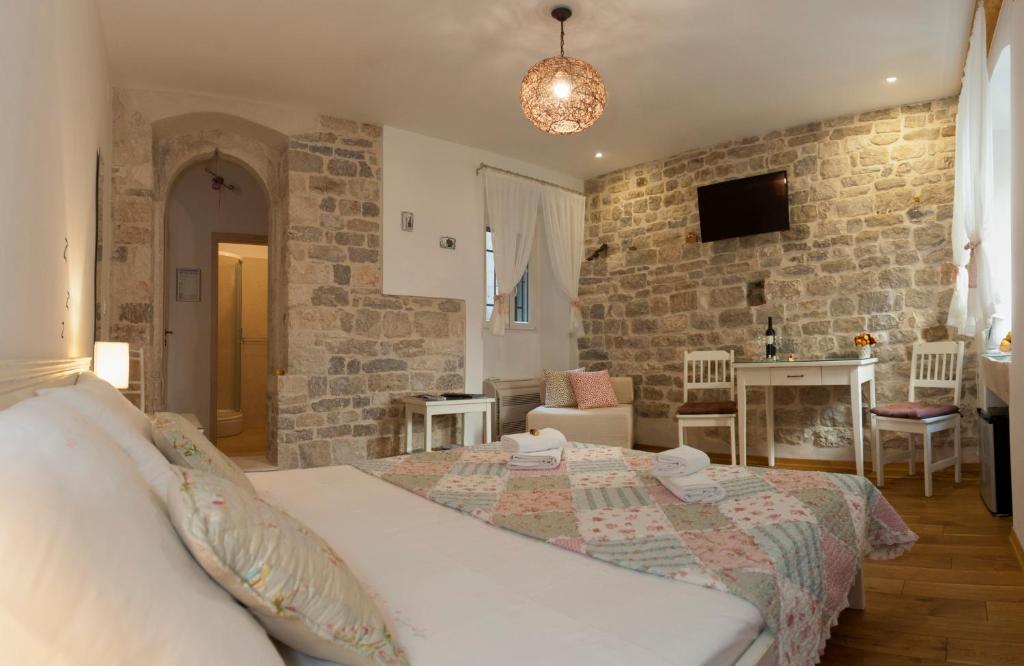 een slaapkamer met een bed en een stenen muur bij Luxury Room Kokola in Split
