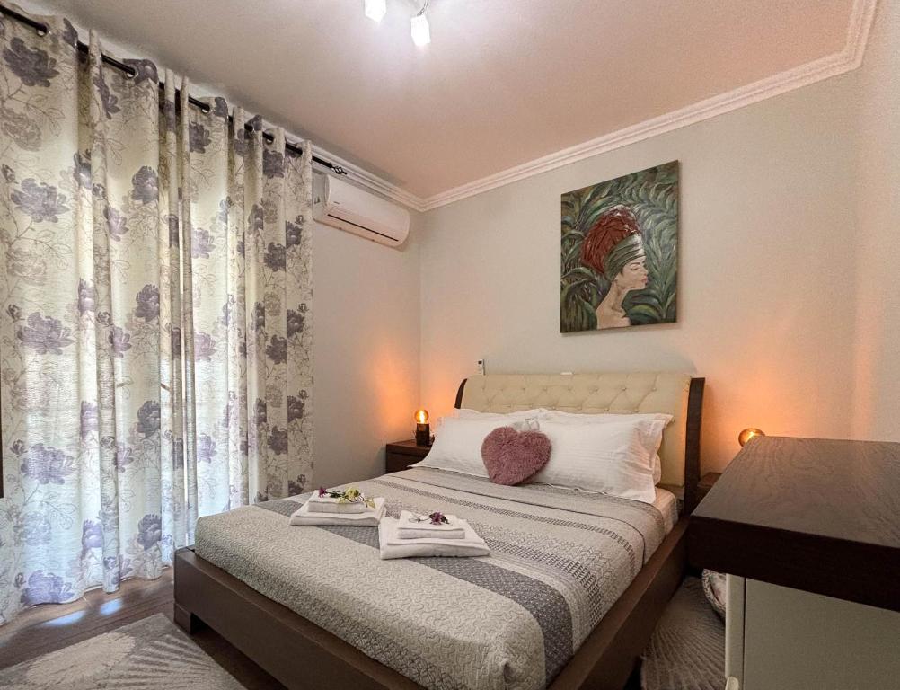 un pequeño dormitorio con una cama y una pintura en la pared en Amy Apartments, en Kassiopi
