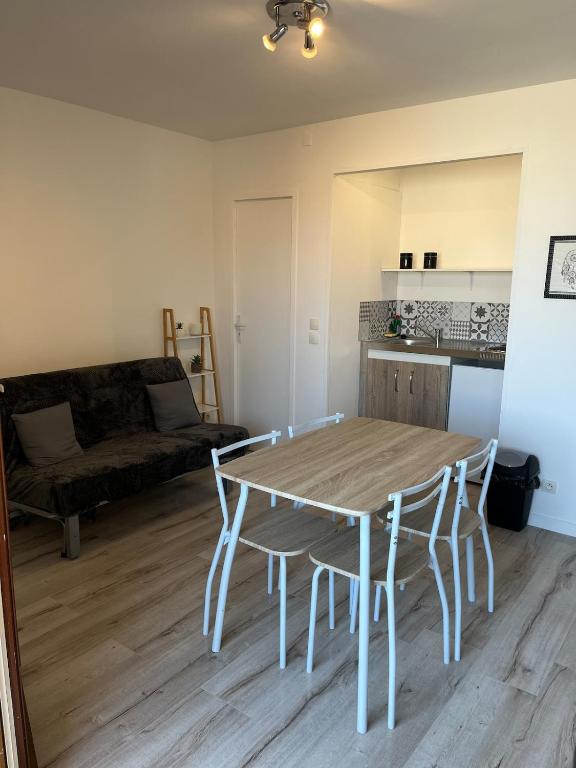 un salon avec une table, des chaises et un canapé dans l'établissement Appart 2 pièces proche plage, à Saint Pierre La Mer
