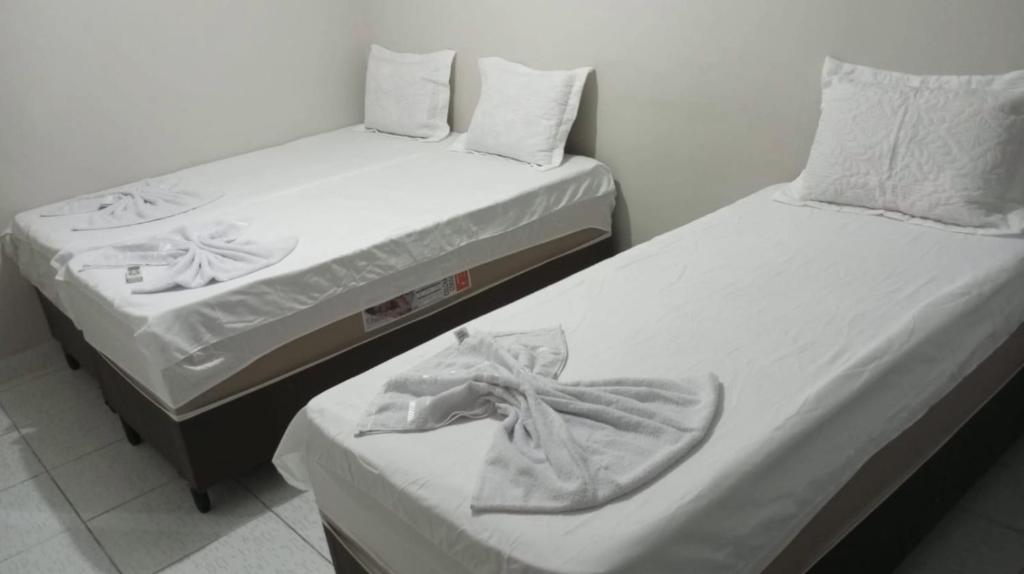 two beds sitting next to each other in a room at Casa de Temporada Maria Rosa in Piranhas