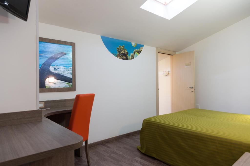 a bedroom with a bed and a desk and a television at Hotel Miramare in Pineto