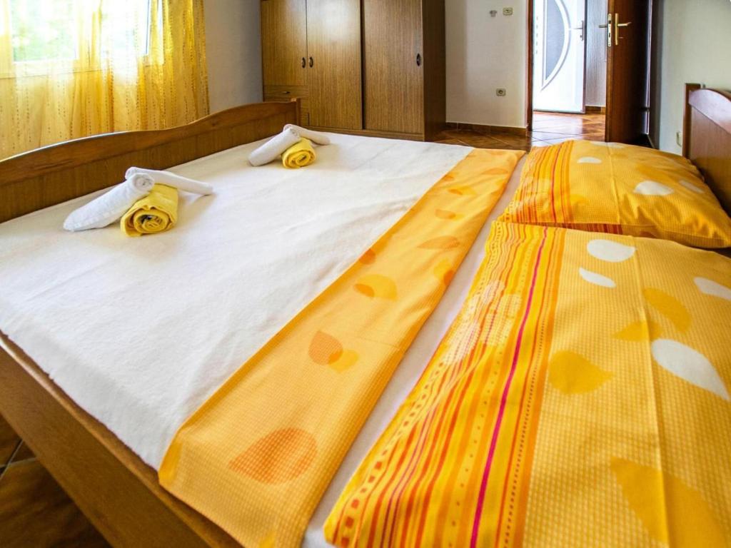łóżko z żółto-białą pościelą i żółtymi poduszkami w obiekcie Apartment in Seline near the sea with seaview w mieście Starigrad-Paklenica