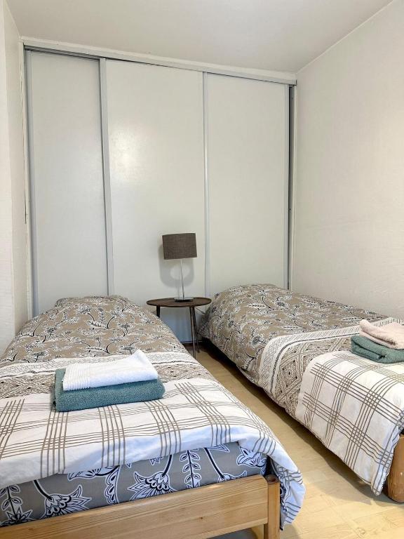 une chambre avec deux lits et une lampe dans l'établissement Chic Apt in Central Paris Ecouffes in Marais, à Paris