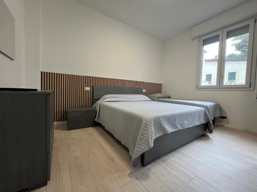 a bedroom with a large bed and a window at Il Villino Lido Spina in Lido di Spina