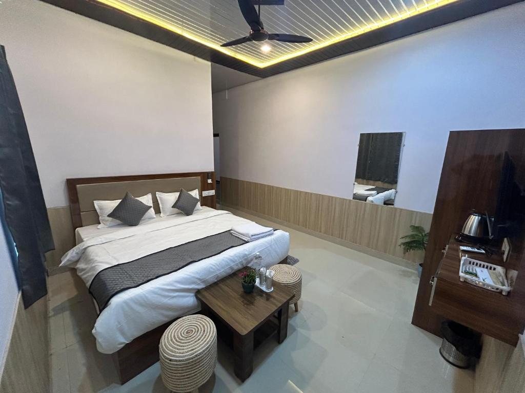 une chambre avec un grand lit et une table dans l'établissement Blackberry Resort Pushkar - Nature with Pool, à Pushkar