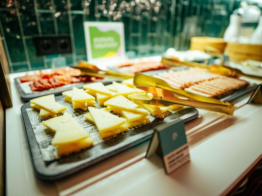 bufet serowy i inne produkty spożywcze na stole w obiekcie Ibis Styles Madrid Centro Maravillas w Madrycie