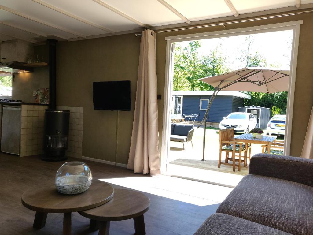 TV a/nebo společenská místnost v ubytování Gemoderniseerd gezellig chalet bij het bos