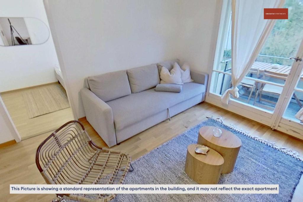 a living room with a couch and a table at Basic 2BR with Natural Light in Zürich