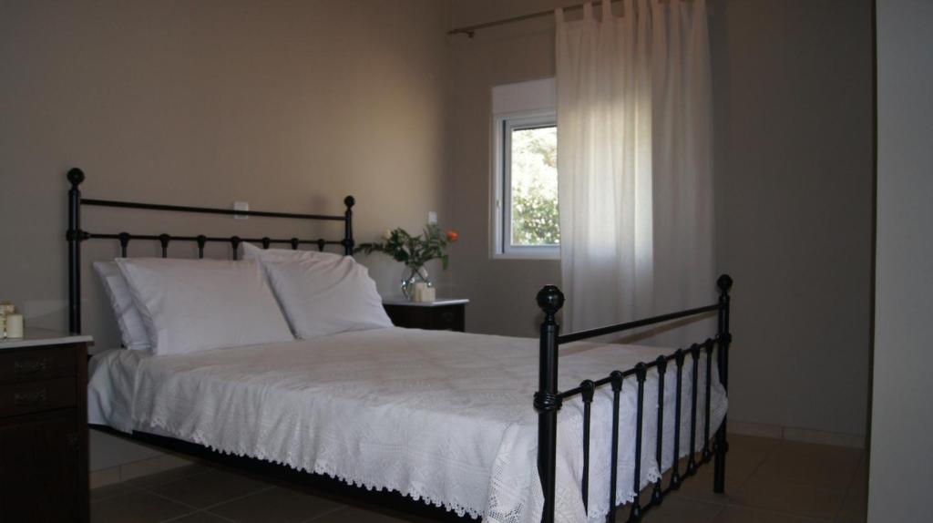 ニキアナにあるEpiskopos Apartmentsのベッドルーム1室(白いシーツ付きのベッド1台、窓付)