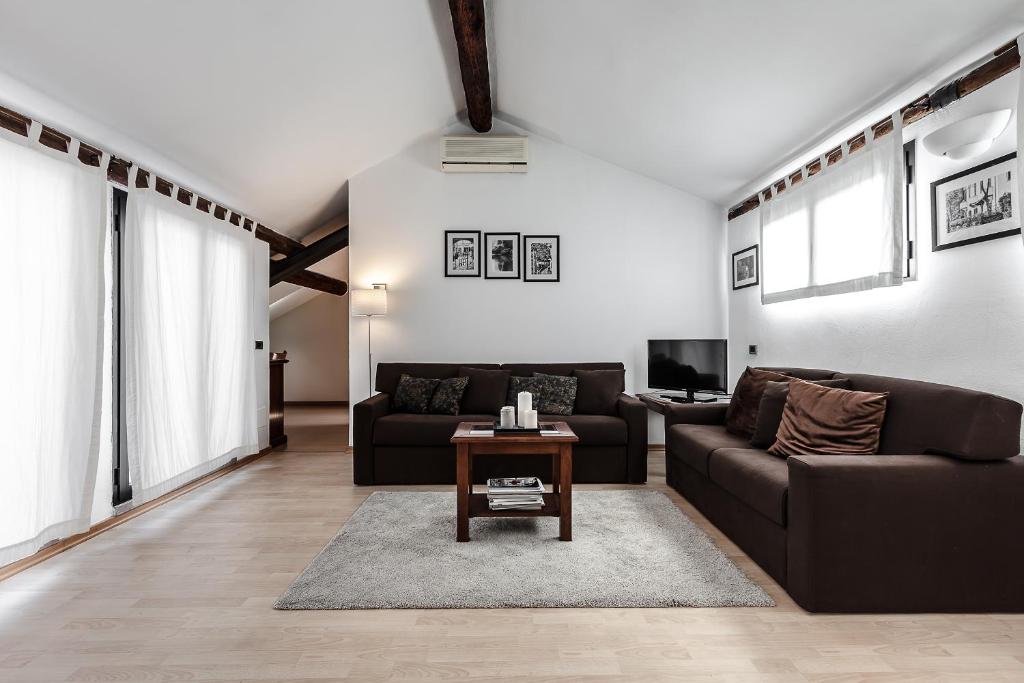 sala de estar con sofá y mesa en MilanRentals - Palazzi Apartment, en Milán