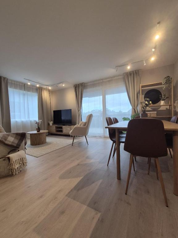 a living room with a table and chairs and a couch at Vakker leilighet i Åros in Søgne