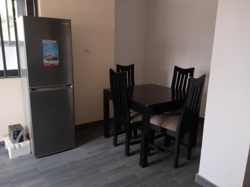 una cucina con tavolo e frigorifero di Appartement 2 chambres salon a Lomé