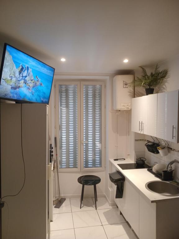 Il dispose d'une cuisine avec une télévision murale à écran plat. dans l'établissement Chambre proche centre ville monuments, à Paris