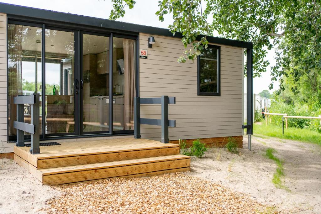 a house with a wooden deck in front of it at Düne 46 in Scharbeutz