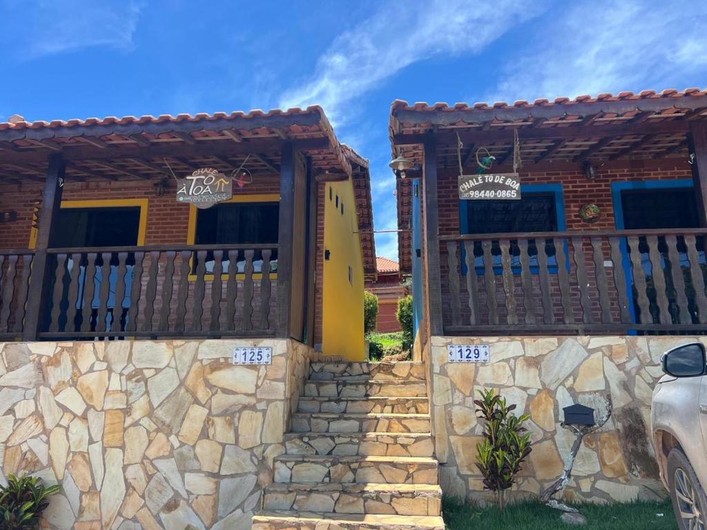 ein Haus mit einem Zaun und einer Steinmauer in der Unterkunft Chalés Toatoa e Tô de Boa - Conceição de Ibitipoca in Lima Duarte