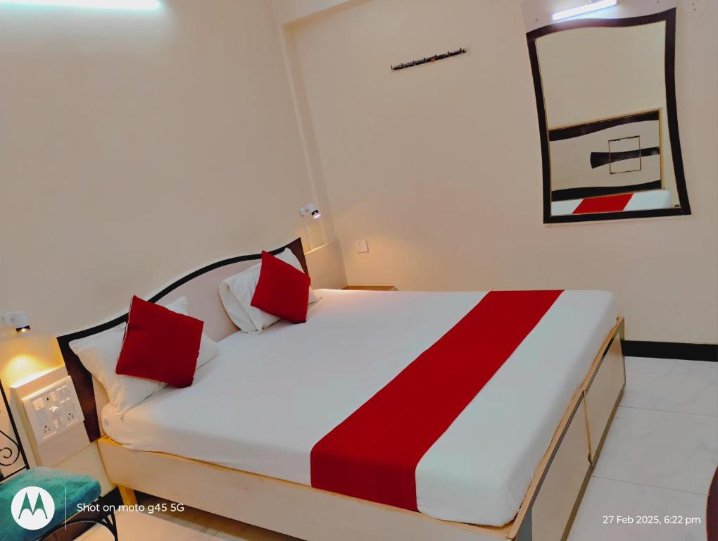 a bedroom with a large bed with red pillows at SAIGAL Guest House in Mumbai
