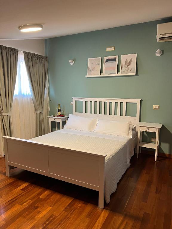 sypialnia z dużym łóżkiem z białą pościelą w obiekcie SIGIS HOTEL - Fiumicino w mieście Fiumicino