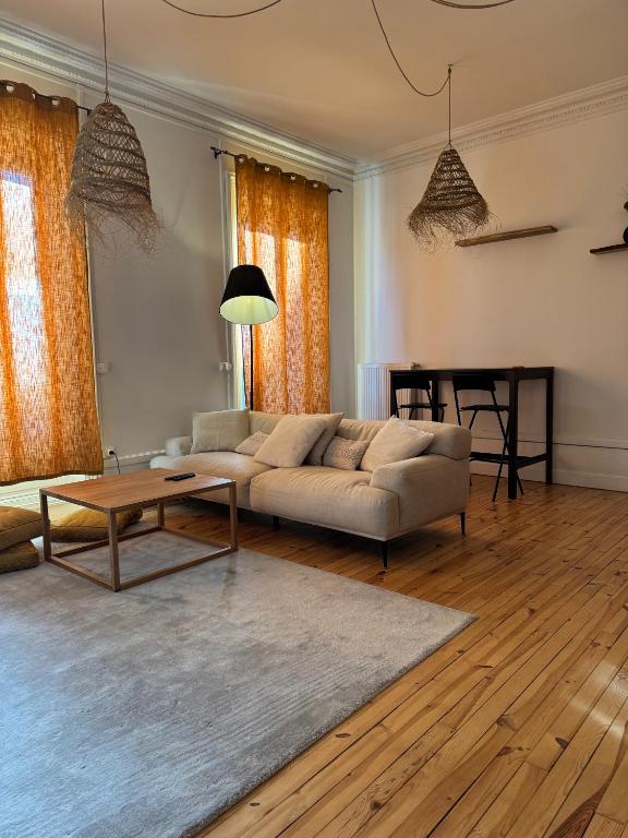 un salon avec un canapé et une table dans l'établissement Le Nid Papin - Haussmanien de standing, à Saint-Étienne