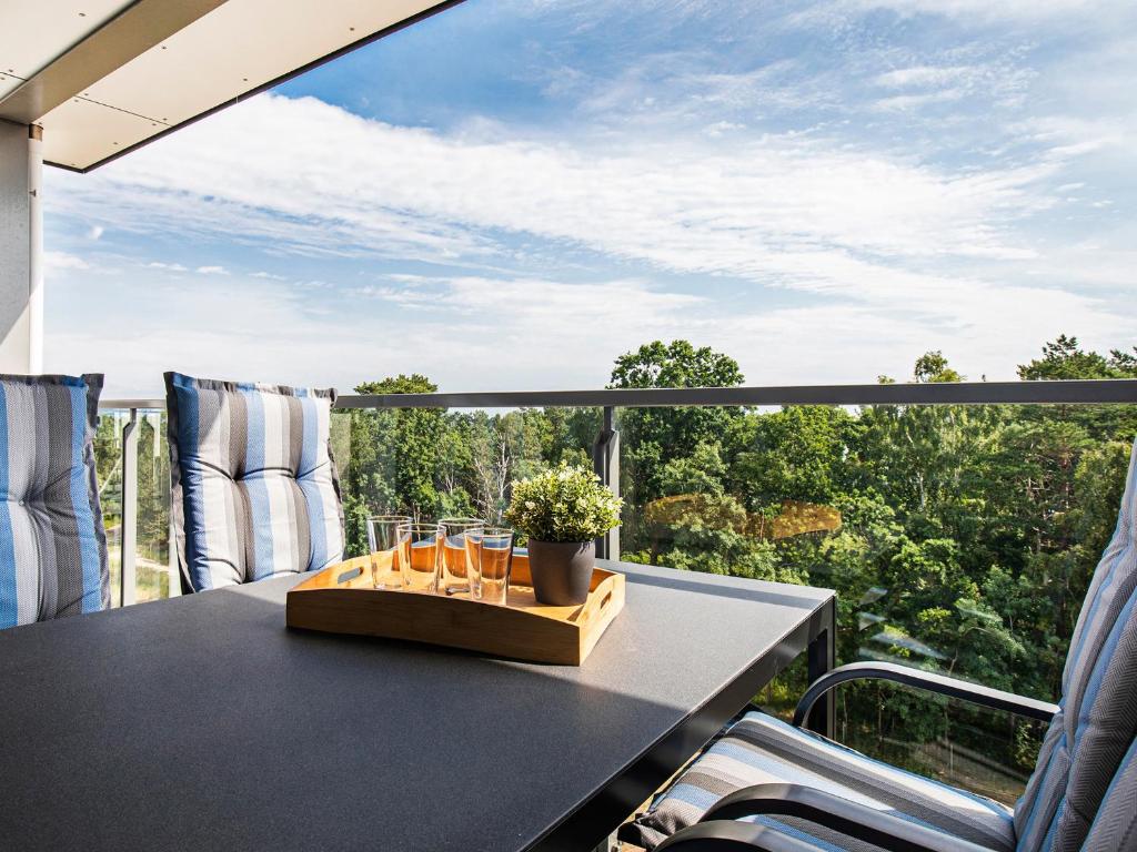 ein Tisch auf einem Balkon mit Blick auf Bäume in der Unterkunft FeWo Prora - Ausblick in Binz
