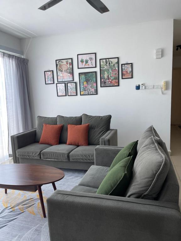 a living room with a couch and a table at Bunga Home with swimming pool access in Lahad Datu