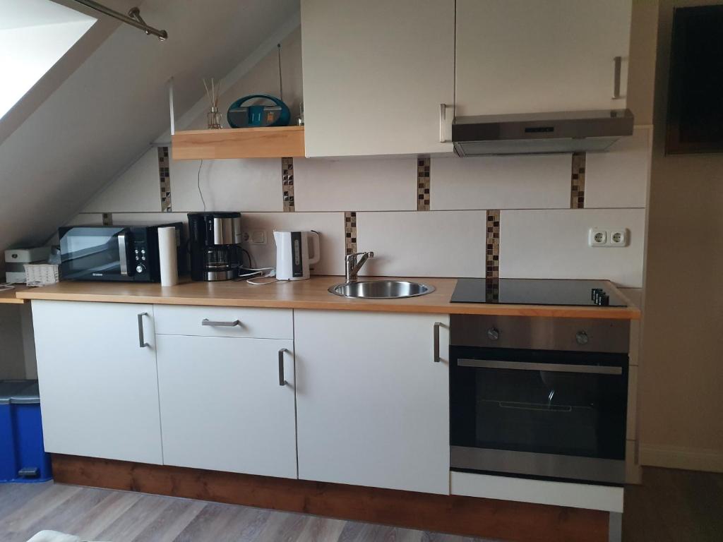 a kitchen with white cabinets and a sink at Ferienwohnung "Kombüse" in Sahrensdorf