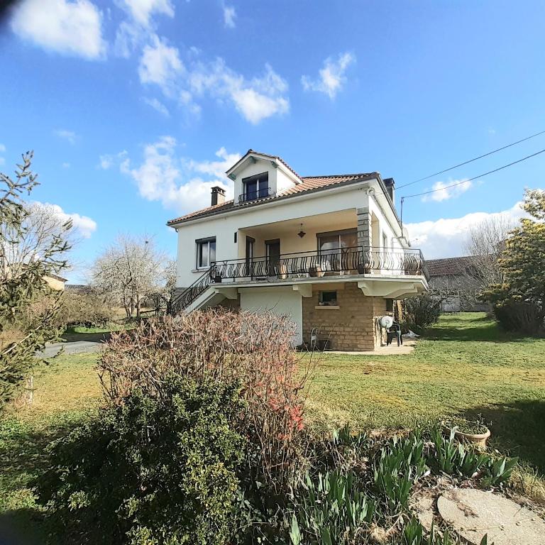 une maison blanche avec un balcon au-dessus dans l'établissement Le Camp Du Tustal, à Saint-Julien-de-Lampon