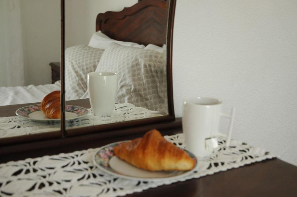 a table with two plates of croissants and a mirror at Casa Delgado in Tavira