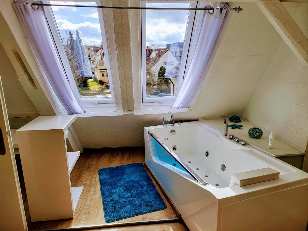 een badkamer met een bad en een raam bij Schwarzwald Residenz in Bad Dürrheim