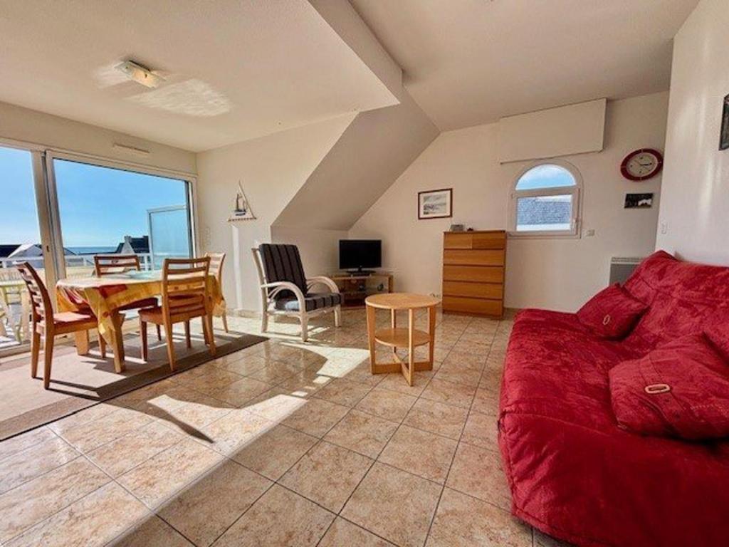un salon avec un canapé rouge et une table dans l'établissement Quiberon - Appartement 2P - 4 pers - Terrasse - Garage - Animaux admis - FR-1-478-79, à Quiberon