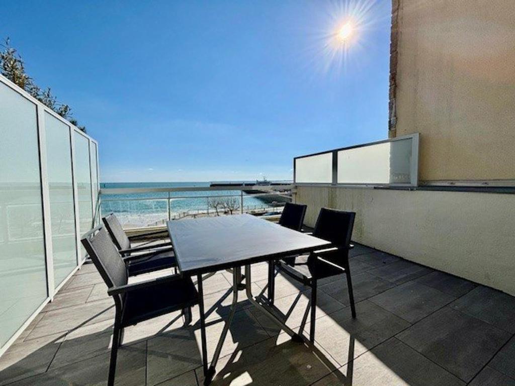 une table et des chaises sur un balcon avec vue sur l'océan dans l'établissement Quiberon - Appartement 2 pièces, grande terrasse face mer, parking, animaux acceptés - FR-1-478-119, à Quiberon