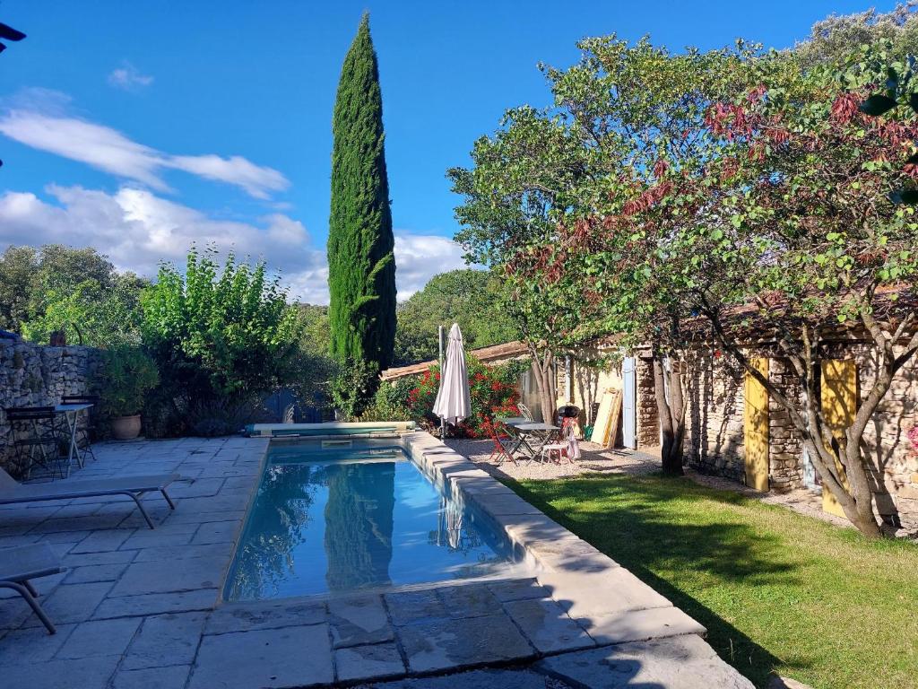 une cour arrière avec piscine et arbres dans l'établissement La Bergerie de Ferrières, à Ferrières-les-Verreries