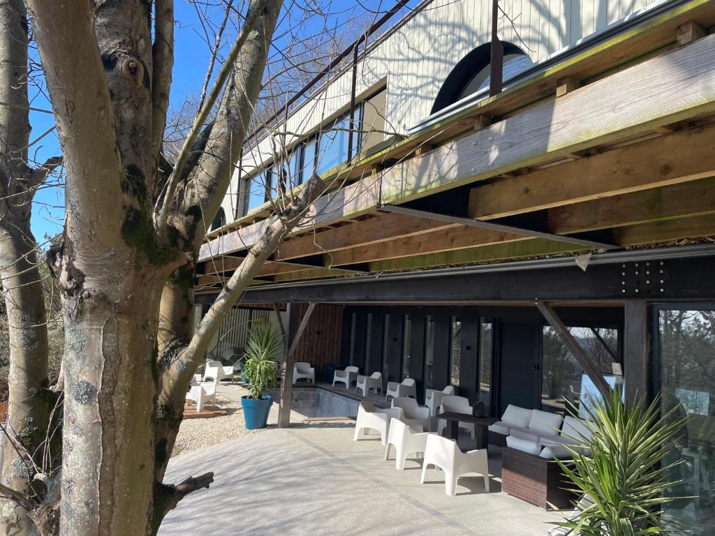 un bâtiment avec des chaises blanches et un pont dans l'établissement La Corniche, Villa d'architecte avec piscine, 2mn mer à Houlgate, à Houlgate