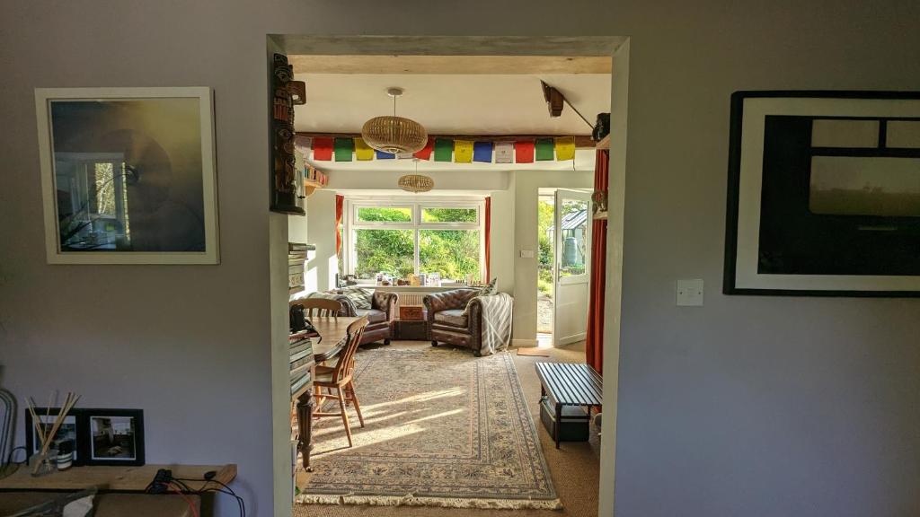 vista su un soggiorno con tavolo e sedie di Rose Cottage a Ledbury