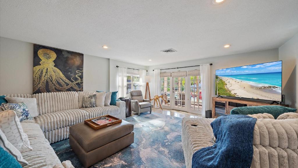 a living room with couches and a view of the beach at Decked Out on Marbury in Longboat Key