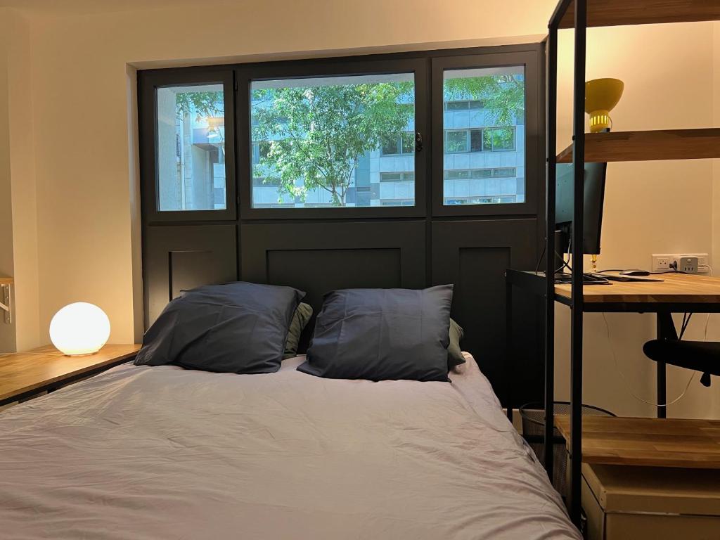 - une chambre avec un lit avec deux oreillers et deux fenêtres dans l'établissement Etage Meynadier, à Paris