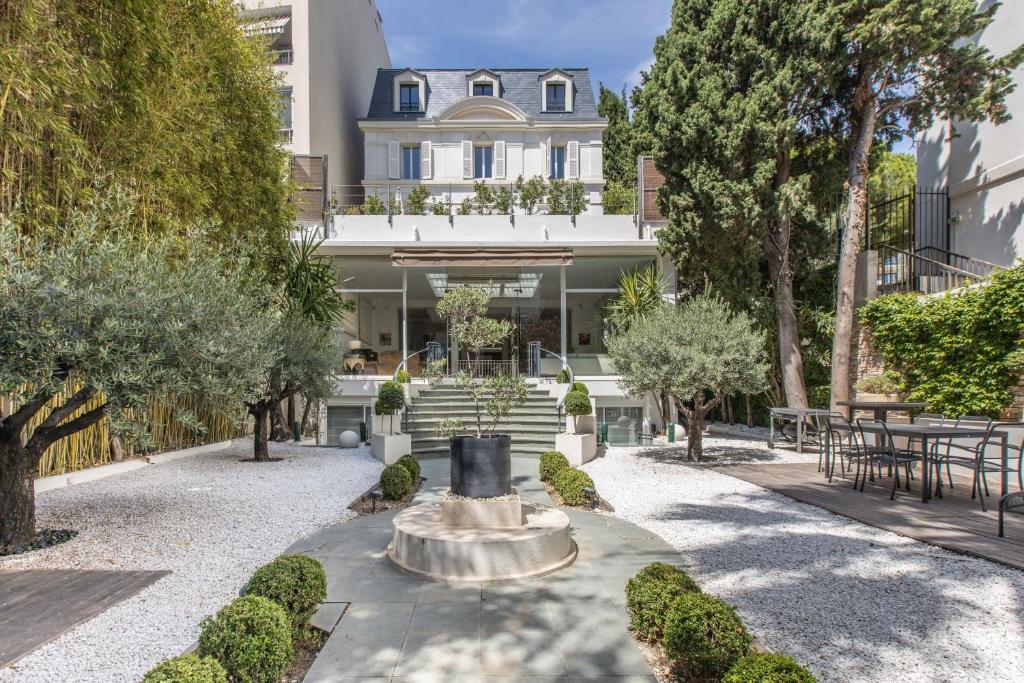 een tuin met een fontein voor een gebouw bij Heart of Cannes Luxury Stay - Steps from Beach & Palais in Cannes