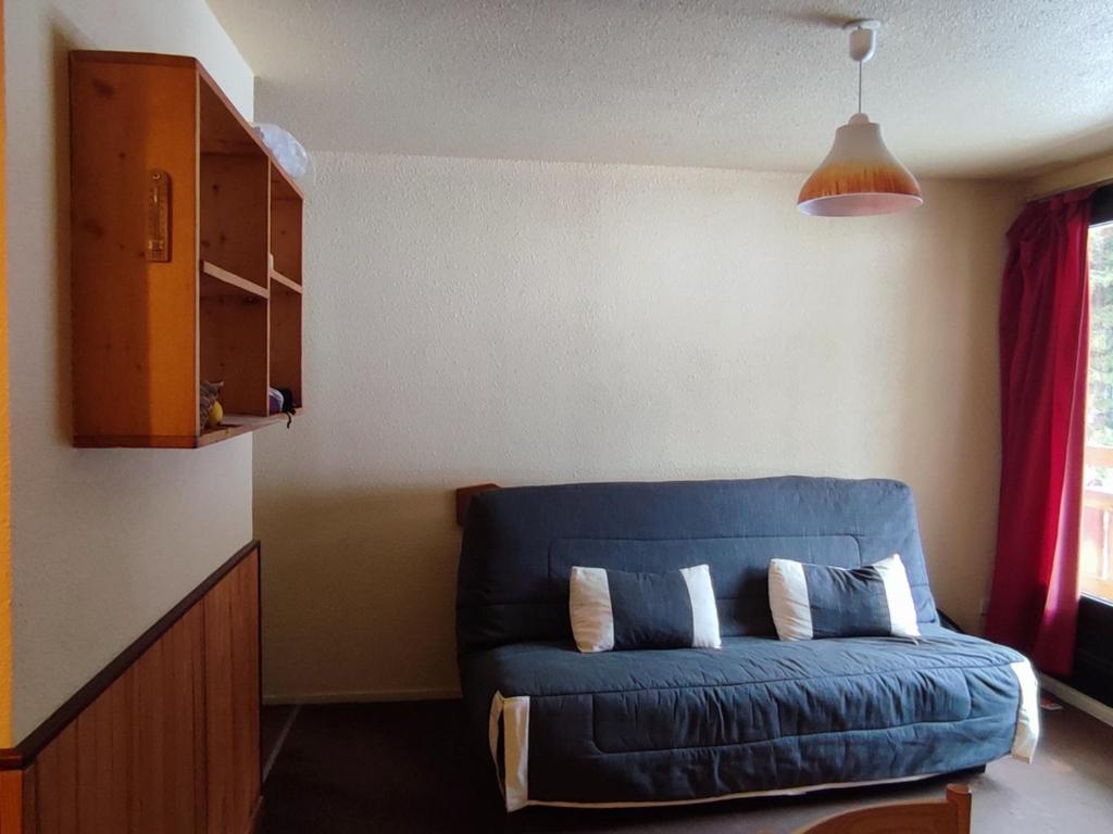 un salon avec un canapé bleu dans une pièce dans l'établissement 2 pièces au pied des pistes, balcon, parking gratuit, proche commerces et ESF - FR-1-557-24, à Les Adrets