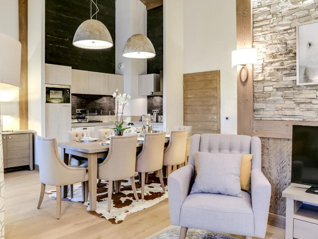 eine Küche und ein Esszimmer mit Tisch und Stühlen in der Unterkunft Appartement 4 pièces de luxe, à deux pas des pistes et commerces, avec parking et accès fitness à Courchevel - FR-1-562-35 in Courchevel