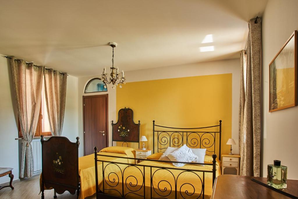 a bedroom with a bed with yellow walls at Agriturismo La Corte di Muggiano in Baggio