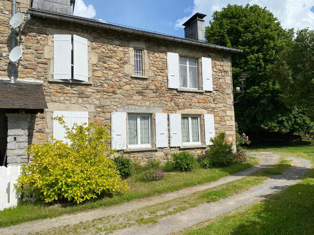 une ancienne maison en pierre avec des fenêtres blanches à volets dans l'établissement La petite maison dans la montagne, à La Salvetat-sur-Agout