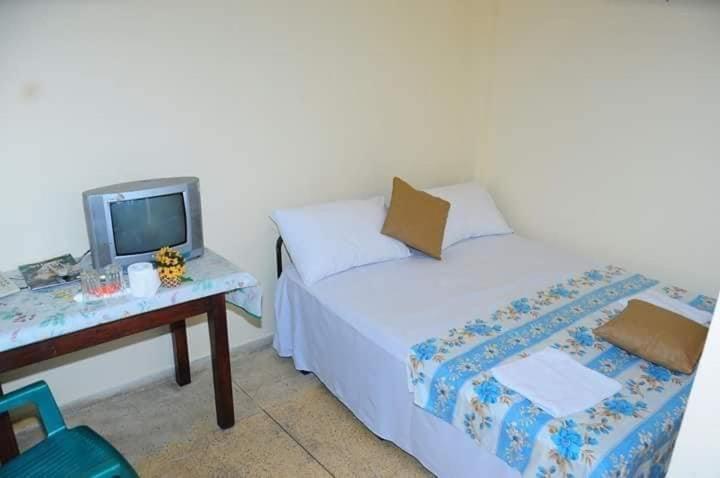 a bedroom with a bed and a table with a tv at Manimalar guest in Colombo