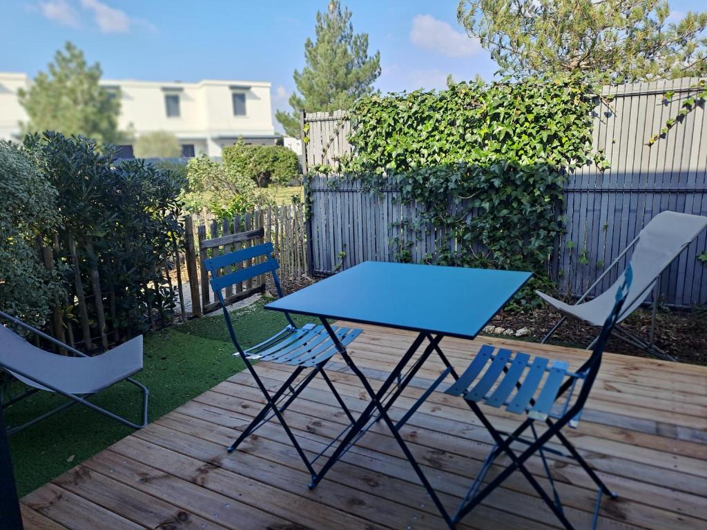 une table bleue et deux chaises sur une terrasse dans l'établissement Platin, à Saint-Palais-sur-Mer